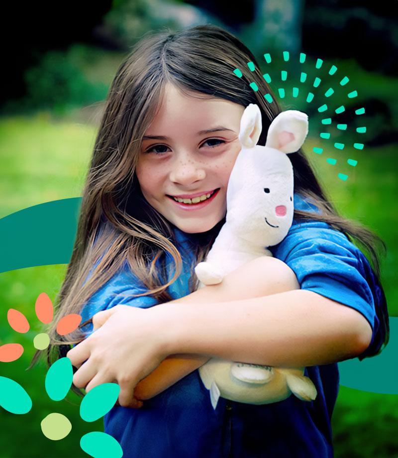 一个小女孩抱着WSECU的兔宝宝毛绒玩具