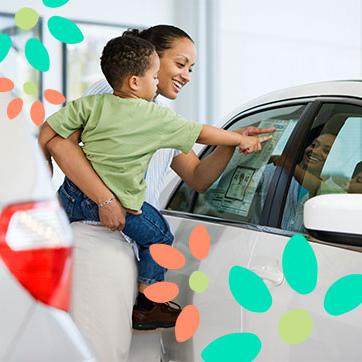 Mother carrying a child while pointing at a car's information sheet